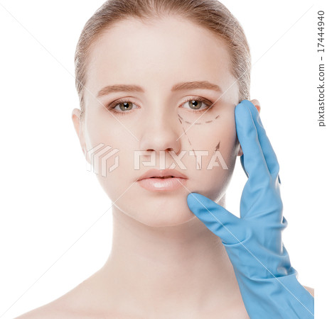 Beautician draw correction lines on woman face 17444940