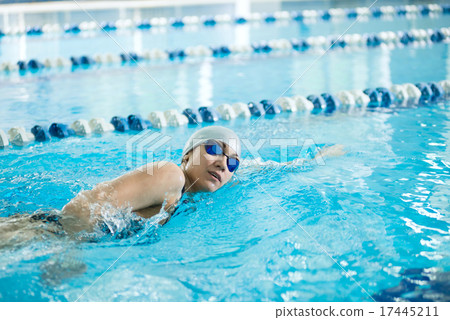 Young girl in goggles swimming front crawl stroke style 17445211
