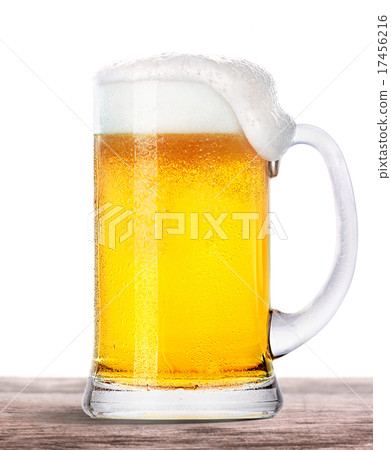 Frosty beer with foam isolated on wooden table 17456216