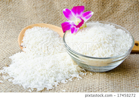 Bowl of raw Thai jasmine rice and wooden ladle Bowl of raw Thai jasmine rice and wooden ladle 17458272
