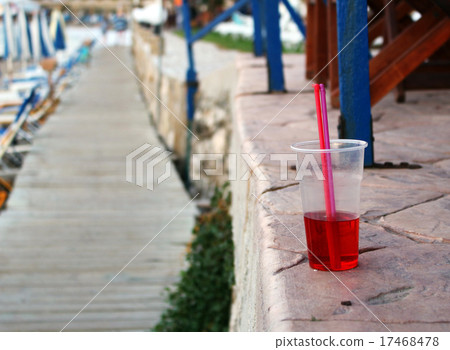 Cold red drink with straw at the beach 17468478