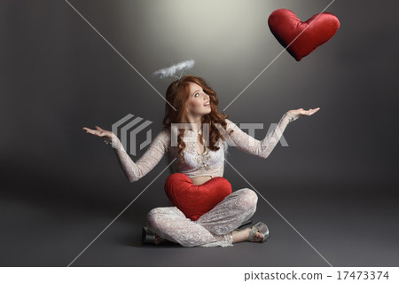 Studio shot of feminine angel playing with hearts Studio shot of feminine angel playing with hearts 17473374
