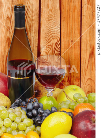 Wine and fruits on background of wooden wall 17477227