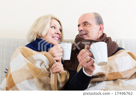 Spouses under blanket drinking tea 17496762