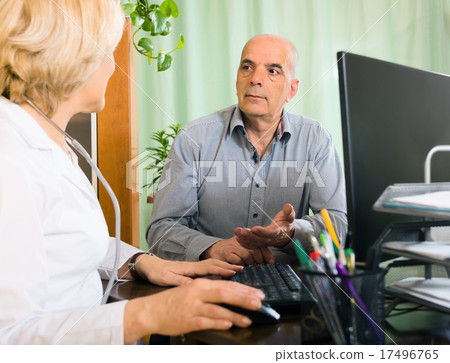 Elderly female doctor talking with mature male patient Elderly female doctor talking with mature male patient 17496765