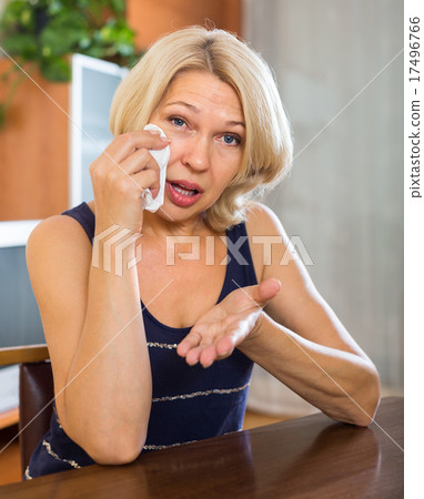 lonely sad mature woman sitting near table lonely sad mature woman sitting near table 17496766