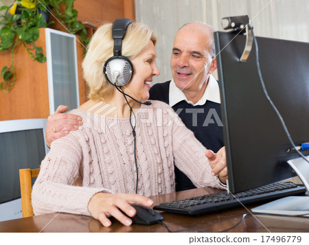 Pensioner sitting together at the computer 17496779