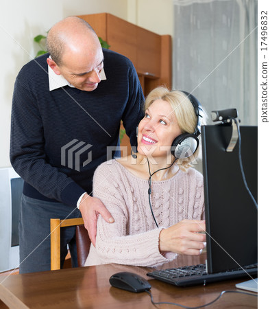 Senior couple using PC at home Senior couple using PC at home 17496832