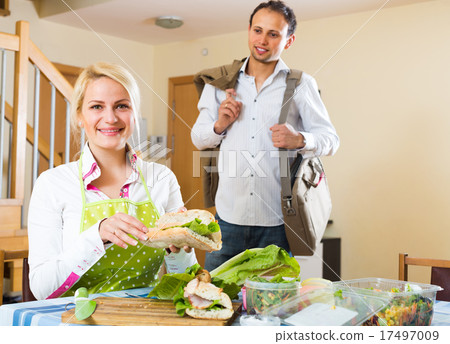 Housewife preparing sandwich for husband 17497009