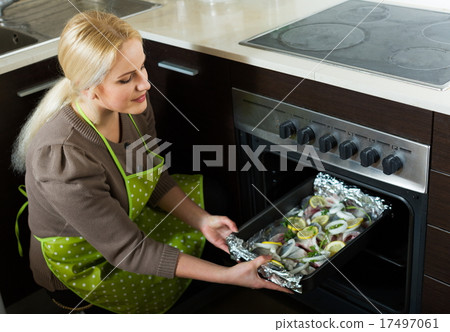Young woman cooking fish Young woman cooking fish 17497061