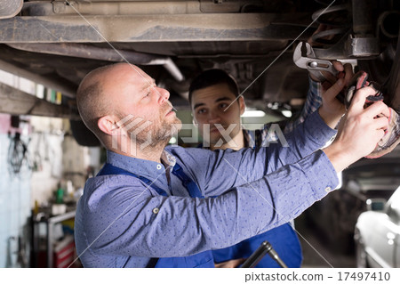 Smiling men in coveralls working Smiling men in coveralls working 17497410