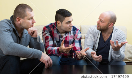 Guys sharing problems at the table 17497499
