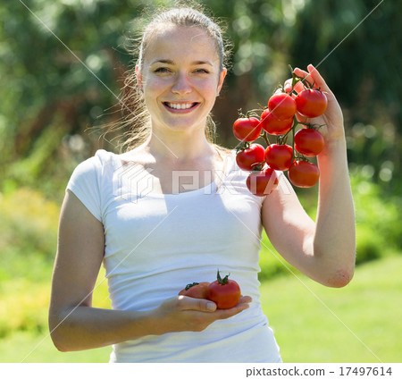 Young woman with tomato in garden 17497614