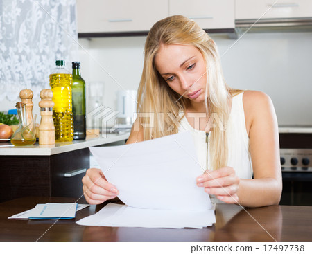 serious woman staring financial documents 17497738