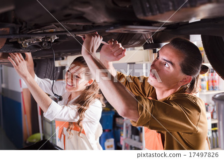 Two mechanics repairing car 17497826