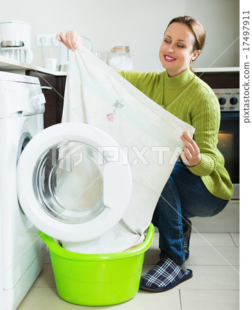 Smiling woman near washing machine Smiling woman near washing machine 17497911