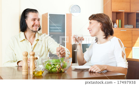 couple eating fresh vegetables and greens in home couple eating fresh vegetables and greens in home 17497938