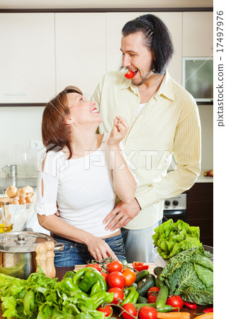happy couple with vegetables in home kitchen 17497976