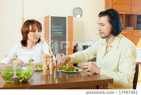 middle aged couple eating vegetarian salad with clear water in t 17497981