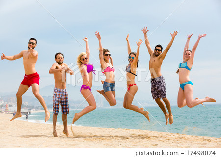Happy tourists jumping on beach Happy tourists jumping on beach 17498074