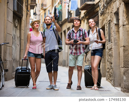 Couples with baggage walking the city. 17498130