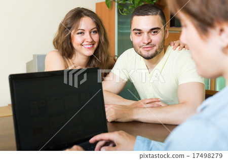 Happy couple talking with employee 17498279