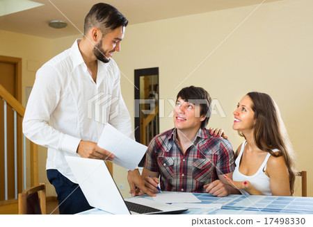 Salesman and young couple at home. 17498330