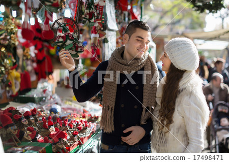 Happy girl with boyfriend choosing Christmas decoration Happy girl with boyfriend choosing Christmas decoration 17498471
