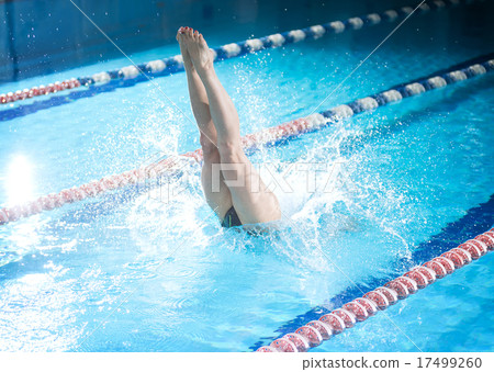 Female swimmer, that jumping into indoor swimming pool. 17499260
