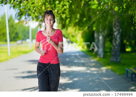 Runner - woman running outdoors in green park 17499494