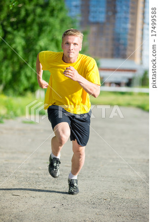 Sporty man jogging in city street park. Outdoor fitness. 17499588
