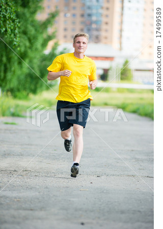 Sporty man jogging in city street park. Outdoor fitness. 17499589