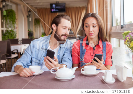Pretty man and woman are using telephones is Pretty man and woman are using telephones is 17501328