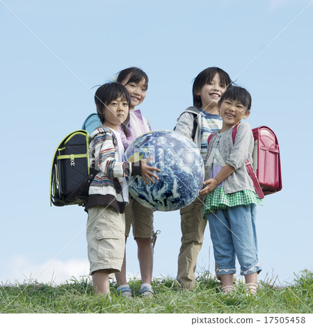 Elementary school student with Earth ball in meadow 17505458