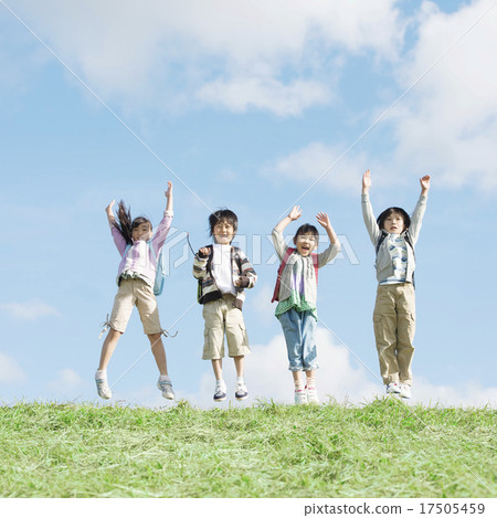 Elementary school student who jumps on the meadow Elementary school student who jumps on the meadow 17505459