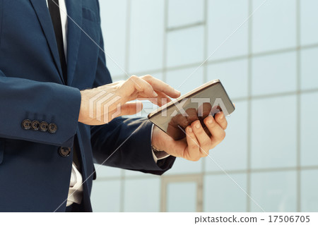 Businessman using a digital tablet outdoors Businessman using a digital tablet outdoors 17506705