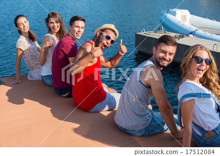 Young people is resting on the quay.  17512084