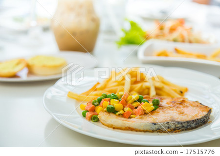 Grilled salmon steak meal served with salad and French fries Grilled salmon steak meal served with salad and French fries 17515776