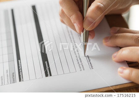 Hand with pen over application form 17516215