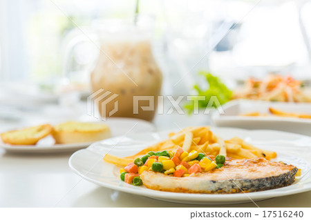 Grilled salmon steak meal served with salad and French fries 17516240