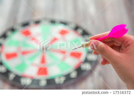 Hand holdin red arrow and throwing to dart board Hand holdin red arrow and throwing to dart board 17516372