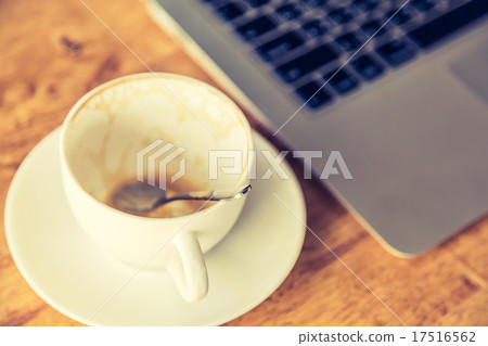 Empty coffee cup and laptop on old wooden table ( Filtered image Empty coffee cup and laptop on old wooden table ( Filtered image 17516562