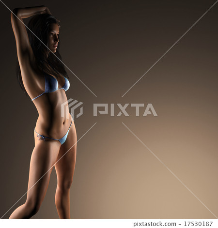 Sexy brunette bikini woman posing in dark studio Stock