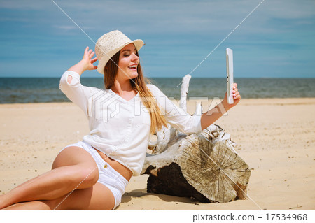 Woman with tablet on beach taking selfie Woman with tablet on beach taking selfie 17534968