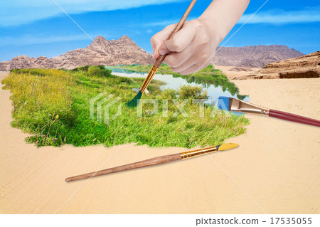 hand with paintbrush paints green meadow in desert hand with paintbrush paints green meadow in desert 17535055