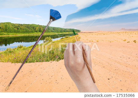 hand with paintbrush paints river in sand desert hand with paintbrush paints river in sand desert 17535066