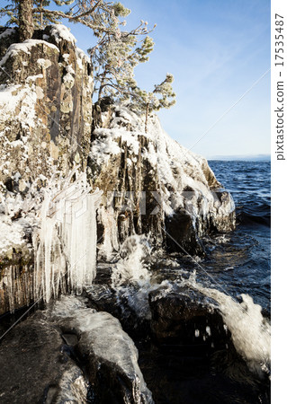 Frozen lakefront rock cliff  17535487
