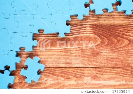 Puzzle on brown wooden background Puzzle on brown wooden background 17535934