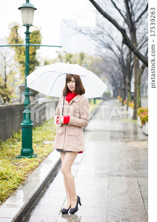 A young woman standing on an umbrella at Nakanoshima Park in Kita Ward, Osaka Prefecture, Osaka Prefecture on a rainy day 17539263