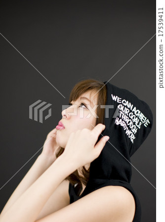 一位年輕的女士，在黑色的背景前穿著引擎蓋，並採取上線的姿勢（向上） 17539411